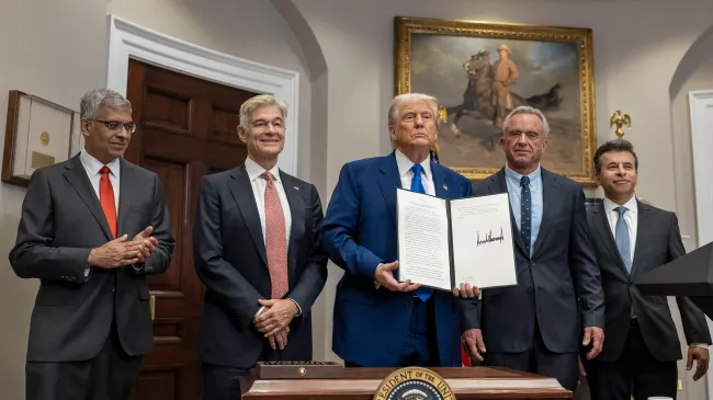 President Trump holds up his signed executive order aimed at lower drug prices
